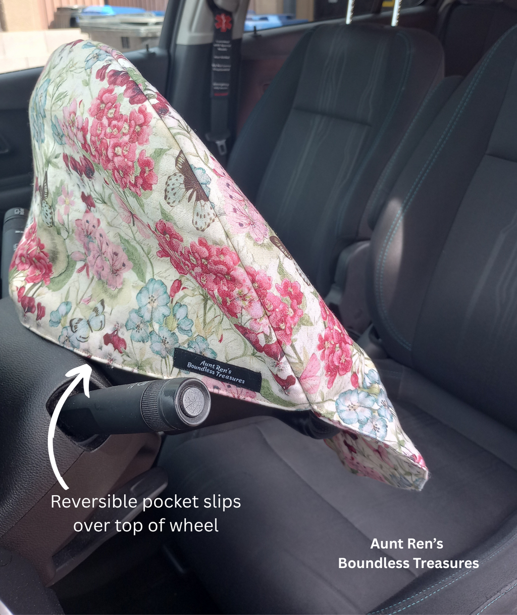 Floral pattern with butterflies on cream fabric slipped over the top of a steering wheel