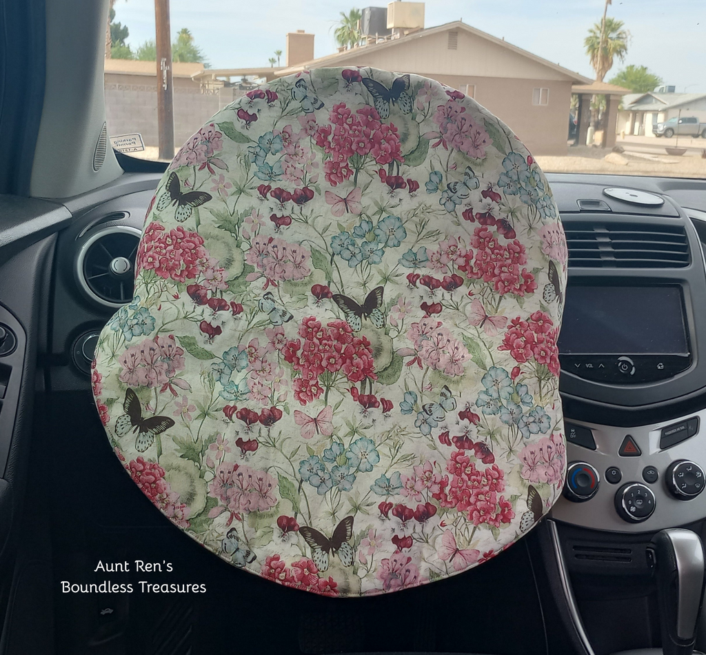Floral patterned with butterflies on cream fabric covering a steering wheel