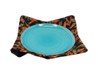 Turquoise plate on a black fabric with chili peppers