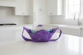 Purple Dragonfly bowl cozy with a strap sitting on a kitchen countertop