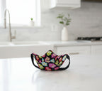 Bowl Cozy with black strap for hand support features colorful owls on black fabric.