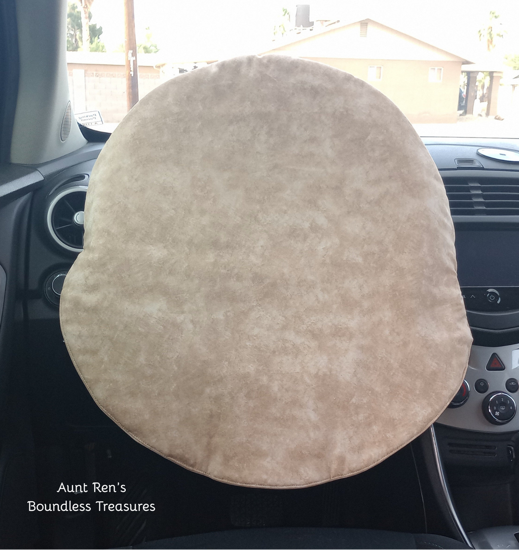 Calico brown fabric cover slipped over steering wheel of a car