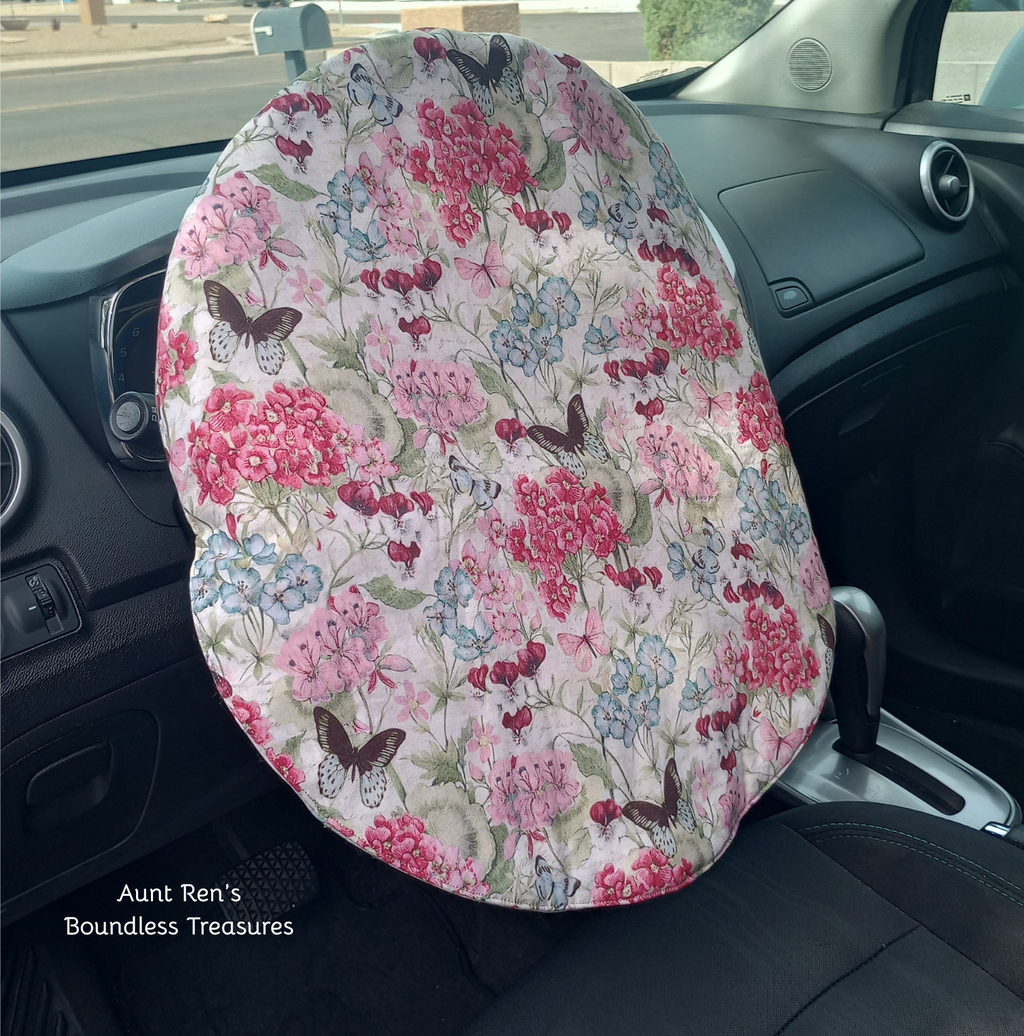 Flowers and butterflies on cream fabric covering a steering wheel