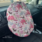 Flowers and butterflies on cream fabric covering a steering wheel