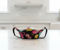 multicolor teapots on black fabric, bowl hot pad with black handles in a kitchen
