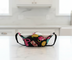multicolor teapots on black fabric, bowl hot pad with black handles in a kitchen