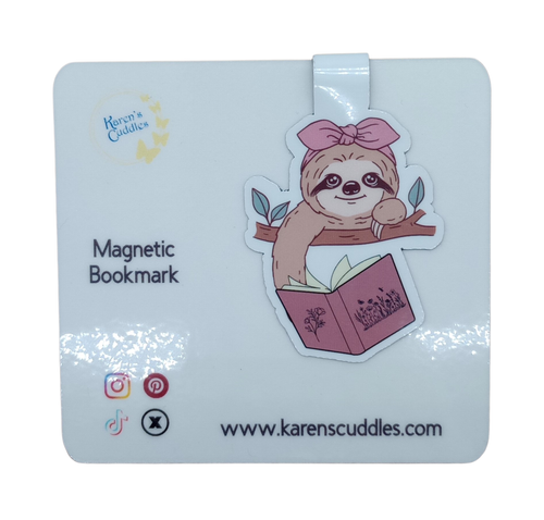 sloth with pink bow leaning over a tree branch reading a book