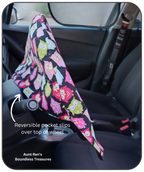 Colorful owl-patterned cover on a car  steering wheel with text indicating it's reversible.
