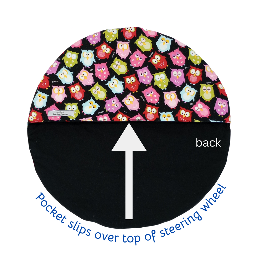 Steering wheel cover with owl pattern on top and black base with arrow and text on bottom, on a white background.