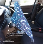 side view of blue steering wheel cover with paw prints and dog bones